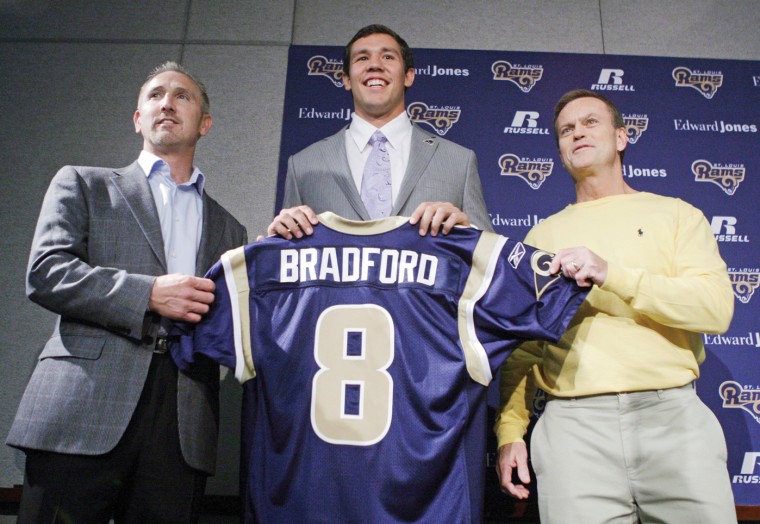 St.+Louis+Rams+quarterback+Sam+Bradford%2C+center%2C+holds+up+his+new+jersey+along+side+Rams+head+coach+Steve+Spagnuolo%2C+left%2C+and+general+manager+Billy+Devaney%2C+right%2C+before+speaking+to+the+media+during+an+NFL+news+conference+on+Friday%2C+April+23%2C+2010%2C+in+St.+Louis.+Bradford+was+selected+as+the+No.+1+overall+pick+by+the+Rams+in+the+first+round.%0A