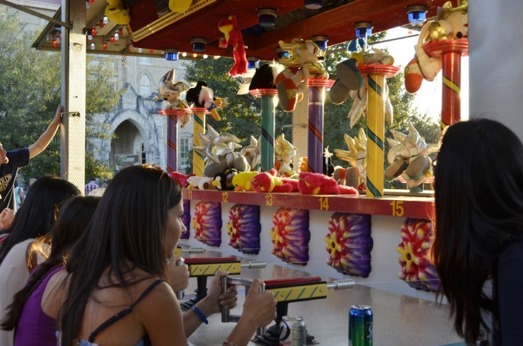 Attendees compete to win prizes by shooting water at a target at the classic carnival game. 
