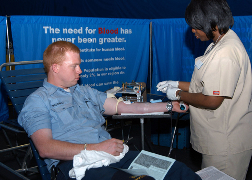 In the hangar bay aboard the amphibious assault ship USS Kearsarge (LHD 3), a New York City blood center worker, Nitisha Moore takes blood from blood donor Electricians Mate 3rd Class Jason McDonald. The blood drive is one of several community-relations projects, which Kearsarge and her crew are participating in during Fleet Week 2006.
