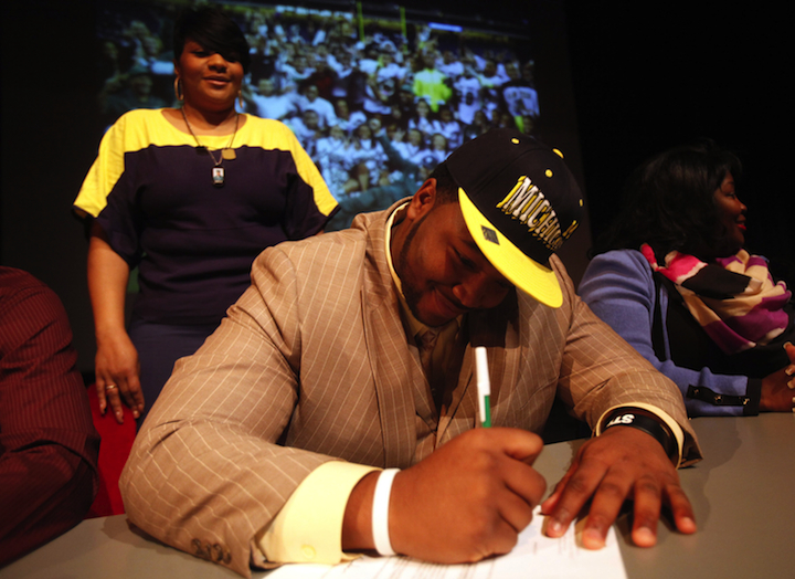 Cass Tech. senior David Dawson signs his letter of intent to play football at the University of Michigan during National Signing Day activities in Detroit, Michigan, Wednesday, February 6, 2013.
