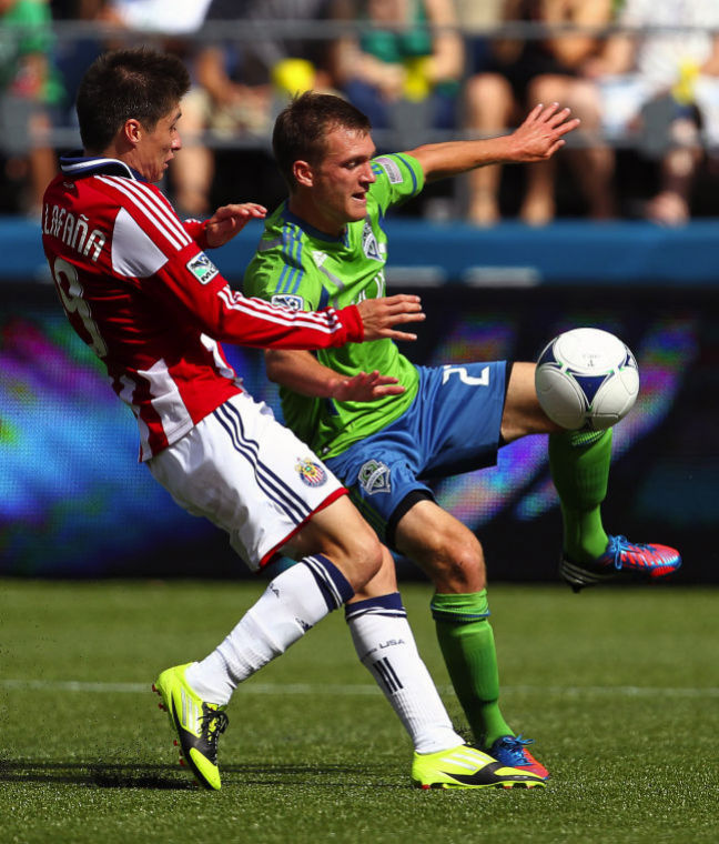 Sounders FC midfielder Alex Caskey, right, attempts to trap a teammate's pass as Chivas USA player Jorge Villafana, left, battles for possession during the second half at CenturyLink Field in Seattle, Washington, Saturday, September 8, 2012. Sounders FC defeated Chivas USA, 2-1. 
