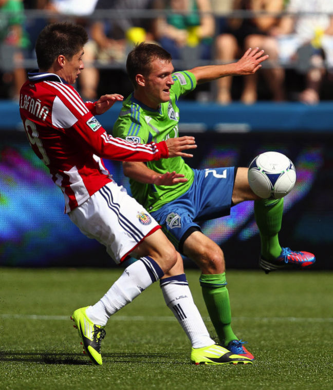 Sounders FC midfielder Alex Caskey, right, attempts to trap a teammates pass as Chivas USA player Jorge Villafana, left, battles for possession during the second half at CenturyLink Field in Seattle, Washington, Saturday, September 8, 2012. Sounders FC defeated Chivas USA, 2-1. 
