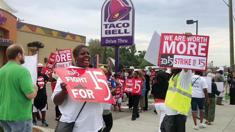 Fast food employees rally outside a restaurant in hopes of receiving an increased wage.