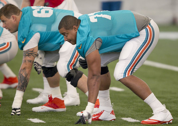 Tackle Jonathan Martin, right, in his stance before ball is snapped during Miami Dolphins practice at the Dolphins training facility at NSU in Davie, Florida, Tuesday, July 23, 2013. 