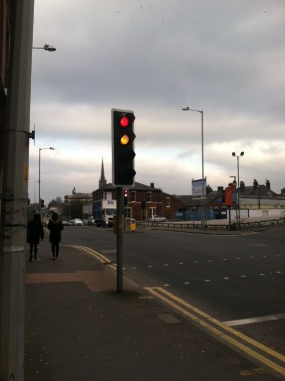 The yellow and red lights together cue the pedestrians to finish crossing and allow drivers to turn their engines back on if they've turned them off for the red light. Funny little differences like this caught me off guard upon arriving in the U.K.
