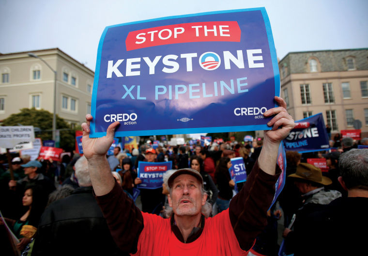 John McCullough holds up his sign protesting the plan to build an oil pipeline from Canada to Texas, called the Keystone XL pipeline, in San Francisco, California, on Wednesday, April 3, 2013. 