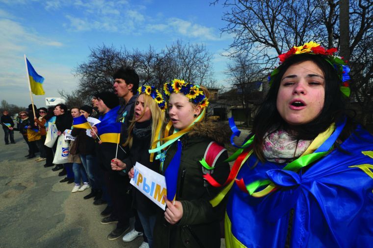 Anti-war demonstrators sing Ukraine's national anthem during a protest action in Simferopol, Ukraine, on Friday, March 14, 2014.