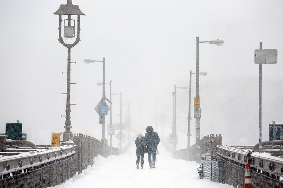 A couple walks across the Brooklyn Bridge in New York on Saturday, Jan. 23, 2016, during a powerful weekend storm blanketing the East Coast in snow. (Carolyn Cole/Los Angeles Times/TNS)