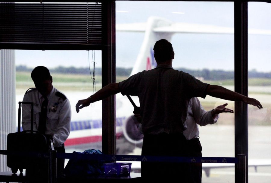 Security personnel at American Airlines screen a passenger prior to boarding, Tuesday, August 13, 2002, at Kansas City International Airport in Kansas City, Missouri.