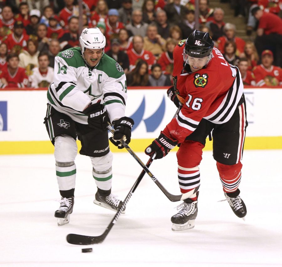 Chicago Blackhawks left wing Andrew Ladd (16) shoots the pack away from Dallas Stars left wing Jamie Benn (14) during the first period of their game on March 22, 2016 at the United Center in Chicago. (Nuccio DiNuzzo/Chicago Tribune/TNS)