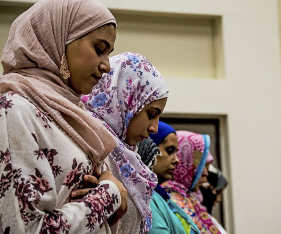 A group of women bowing their heads in prayer.