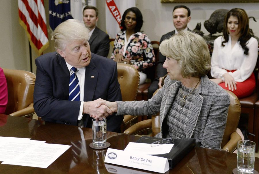 President Donald Trump congratulates Education Secretary Betsy DeVos during a parent-teacher conference listening session in the Roosevelt Room of the White House Feb. 14 in Washington.