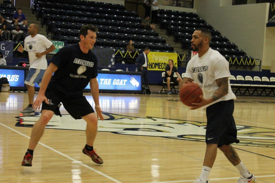 Taylor Land (left) guards John Rutherford (right) at the men’s basketball alumni game Feb. 18.