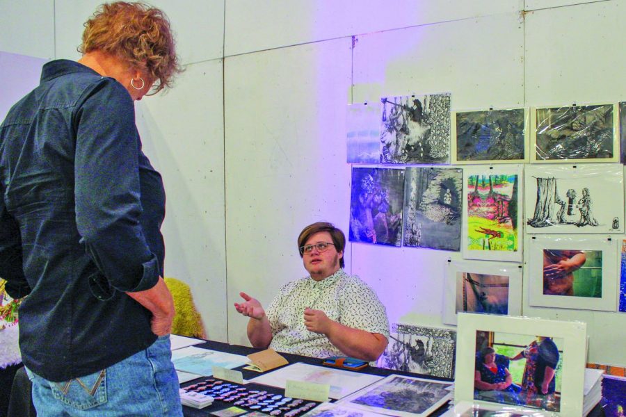 Printmaker Nelvin Cecil Howell discusses some of (their) artwork with a guest.