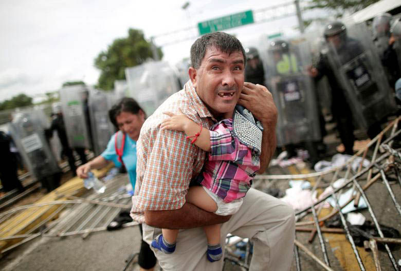 A father cradles his child as violence breaks out between police and the caravan.