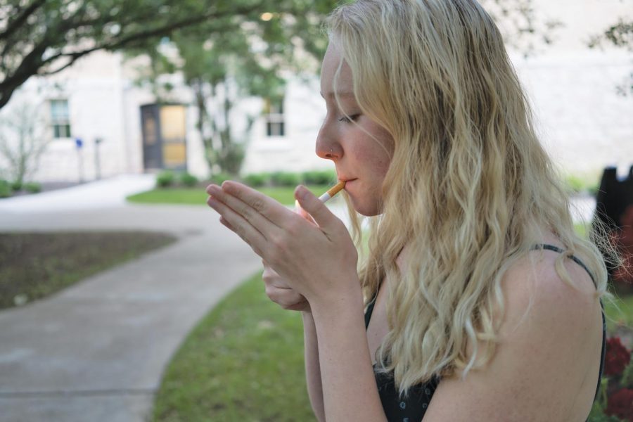 A student sits by the seal smoking a cigarette. A bill filed in the legislature seeks to reduce underage smoking by increasing the minimum legal age to purchase tobacco/vape products.