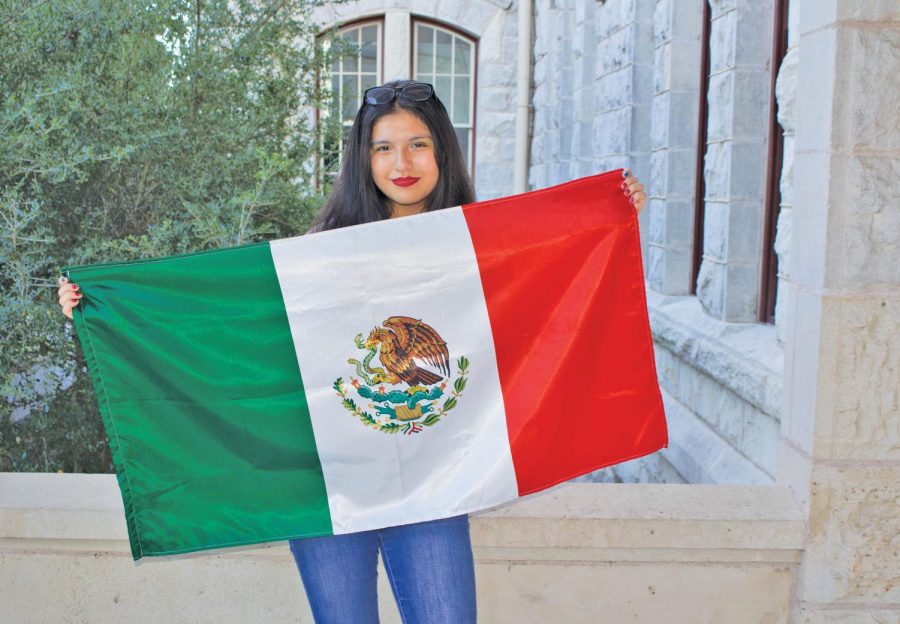 Isabel Herrera holds Mexican Flag in honor of her parents from Mexico. 