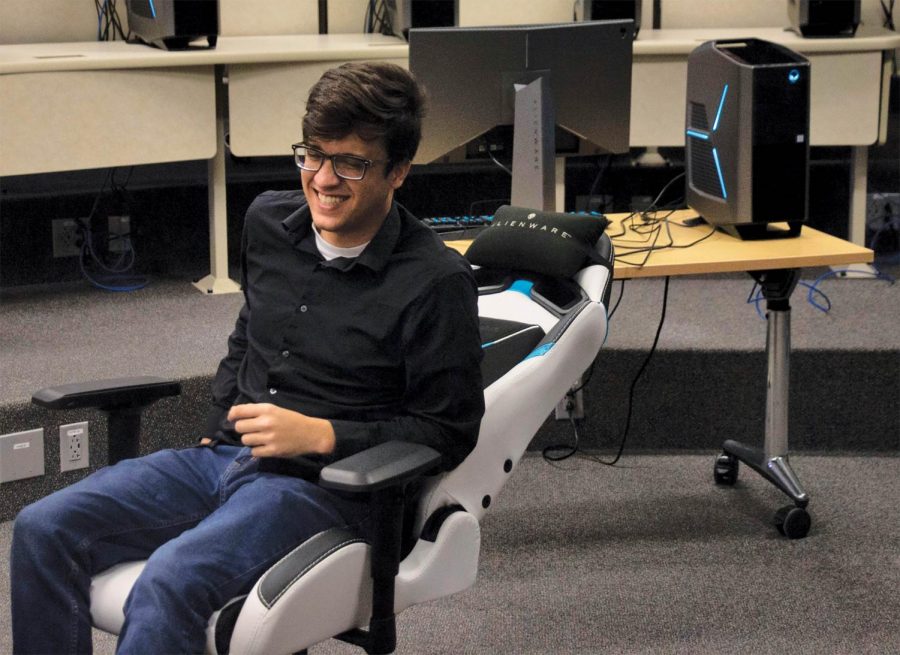 David Willis, SEU’s first esports coach, sits in the new gaming arena which includes professional gaming equipment.