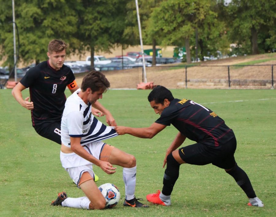 Parker Frye and an opposing player fight for possession of a loose ball. Frye’s jersey is also being illegally tugged. 