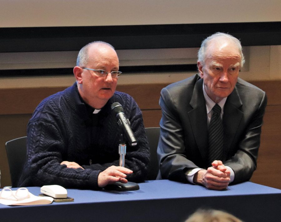 (Left to right) Father Peter Walsh, Director of Campus Ministry, and President Martin sit on the panel for the annual meeting. Martin emphasized the Holy Cross mission at the start of the event.