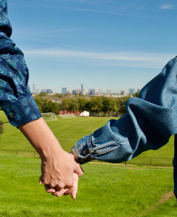 Sophomores Maddie Benbenek and Pete Cervantes hold hands in front of campus’ popular view of Austin’s skyline.
