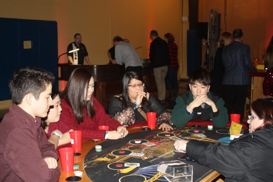 A visiting family plays blackjack at the casino section of the Homecoming Bash. Guests could trade in tokens won during gambling for raffle tickets for a chance to win prizes such as AirPods, a FitBit and more.