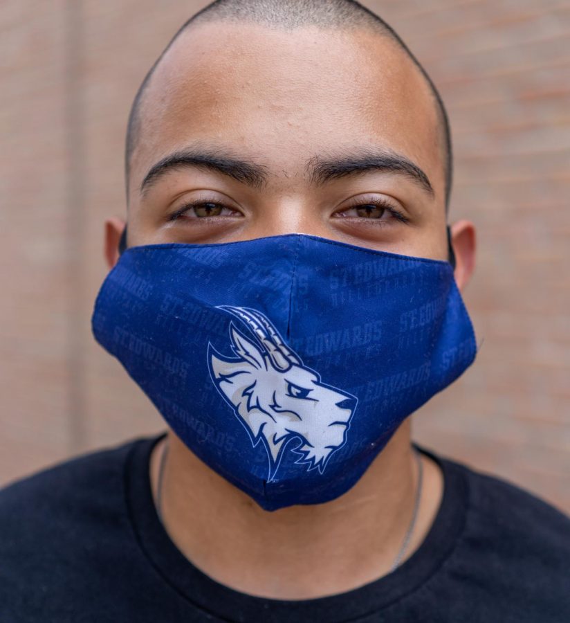 St. Edward’s student Isaiah Bass is following guidelines by wearing his Topper mask. Masks like these can be purchased at St. Edward’s bookstore.