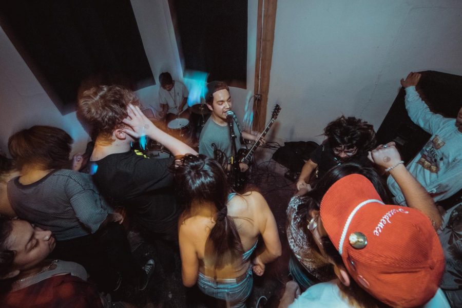 San Martin (middle) can be seen performing at a DIY-style concert. These types of performances are common in the underground San Antonio music scene. 