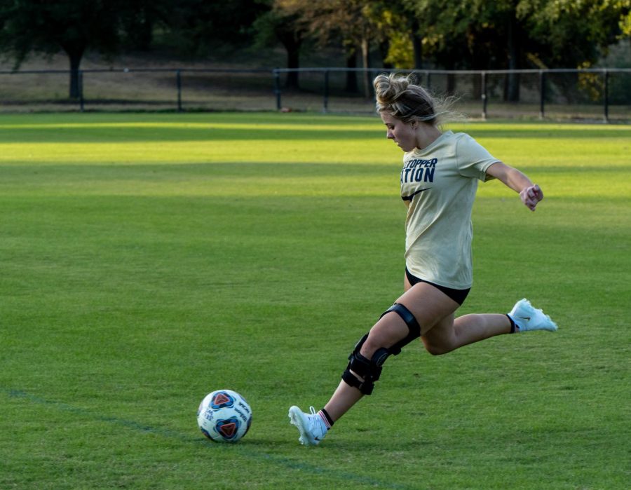 Freshman Katelyn Smith strikes a ball on the Lewis-Chen Family Field on campus. The midfielder is part of the womens soccer team at St. Edwards that last year had an overall record of 13-7-2.