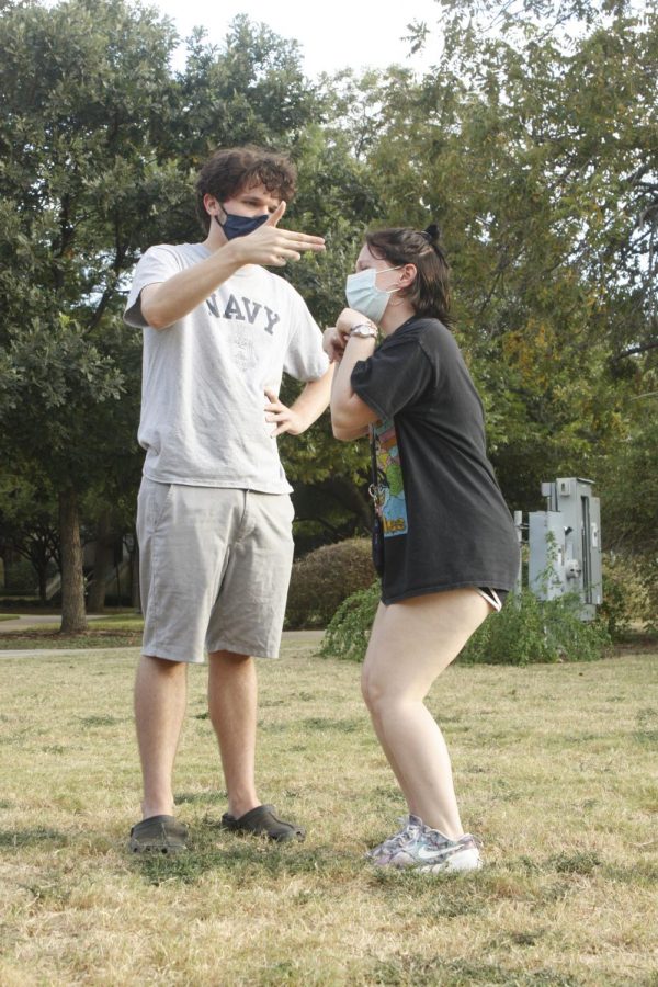 St. Edwards University students Coleman Hahn (left) and Gwendalyn Waggoner (right) playing “Freeze,” an improv game  in which two players enact a scene and switch with other players when told to freeze. 