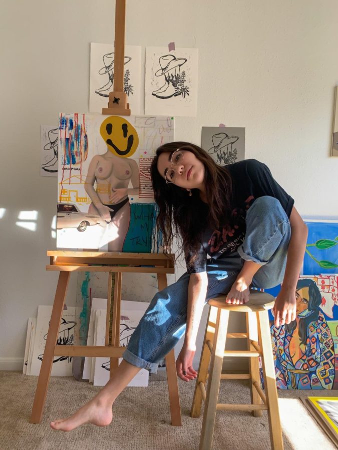 St. Edward's University senior Emily Bryn poses in front of her artwork. Bryn is currently pursuing her degree in art.