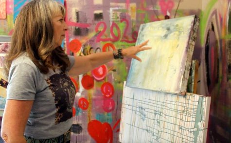 Donna Dugone, showing off a painting in her studio. Dugone is a local artist that works mostly with paint. 