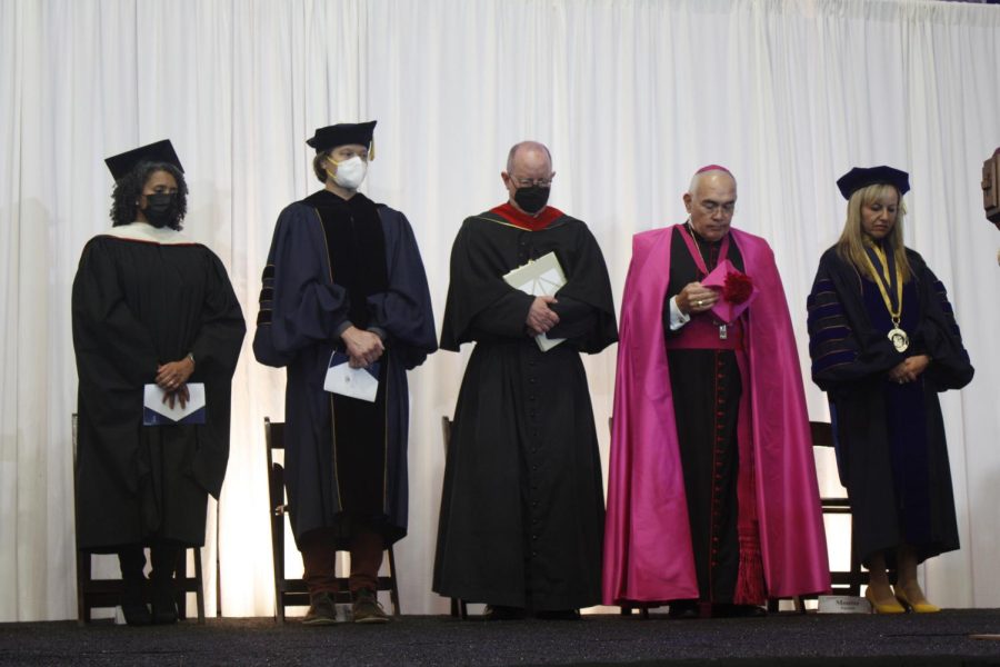 (left to right) Laura Lucas, Jason Callahan, Father Peter Walsh, Reverend Joe S. Vásquez and Fuentes bow their heads in prayer.