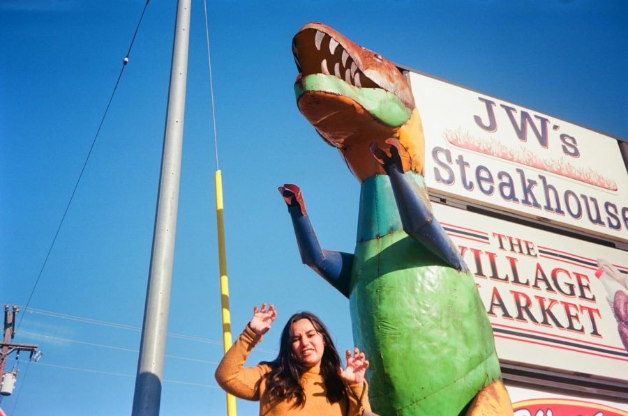 Ally poses with a colorful dinosaur statue outside JW's Steakhouse. 