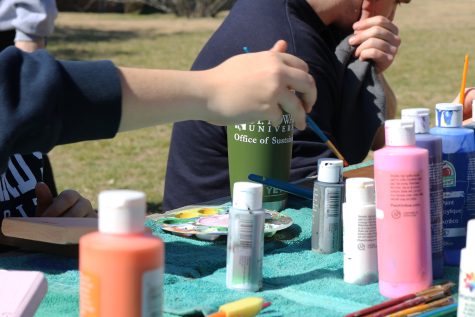 During a colorful workday at the campus garden volunteers re-painted chairs and benches, and chose rocks to paint for the growing rock garden.