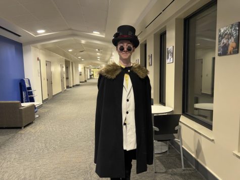 Hern pulls off a whimsical outfit that has turned them into a campus celebrity at SEU. Hern shows off their top hat, decorated with white and black flowers  and completes the look with a pair of circle sunglasses. 