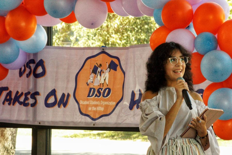 Nic Chuecas presenting in front of attendees, surrounded by colorful balloons. They were representing Monarchs on the Hilltop and explained the symbolism behind the organizations logo: the monarch butterfly.