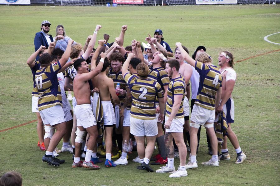 Team members gather in celebration over their homecoming win against University of Houston.