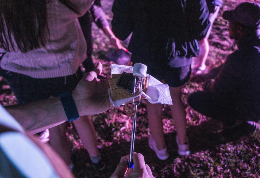 Gerad Sandate puts together his s’more after roasting a marshmallow on the fire with friends. 