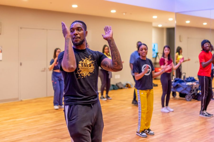 Tate stands with step class attendees in the middle of teaching.