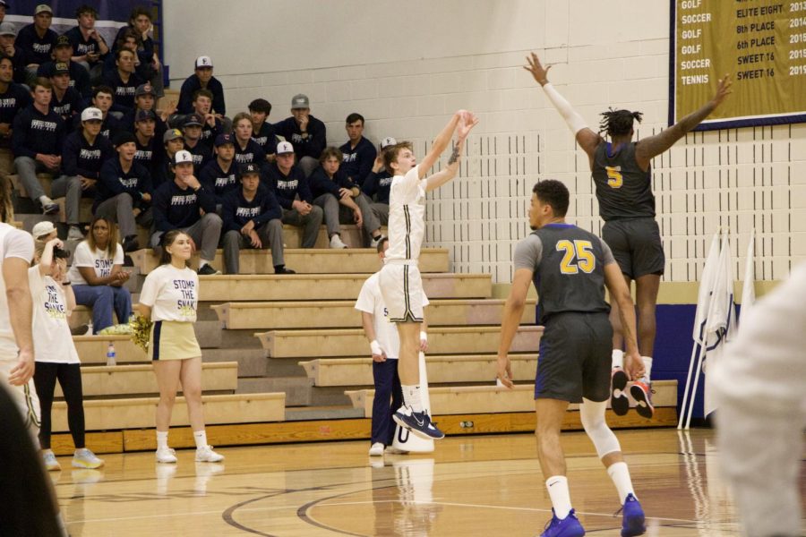 Sophomore Blake Nielsen jumps for a three-pointer shot over Rattlers Edward Manuels hand.