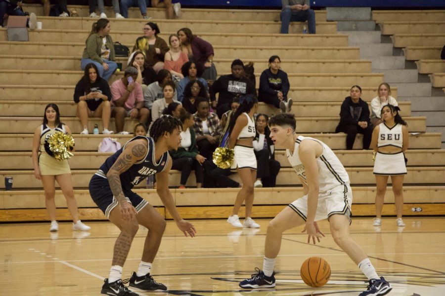 Sophomore guard Gavino Ramos, who got his first collegiate double-double, dribbles the ball trying to find space for a shot.