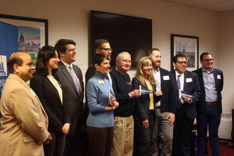 University alumni stand with President Fuentes and Brother Daly, CSC, for a group picture.
