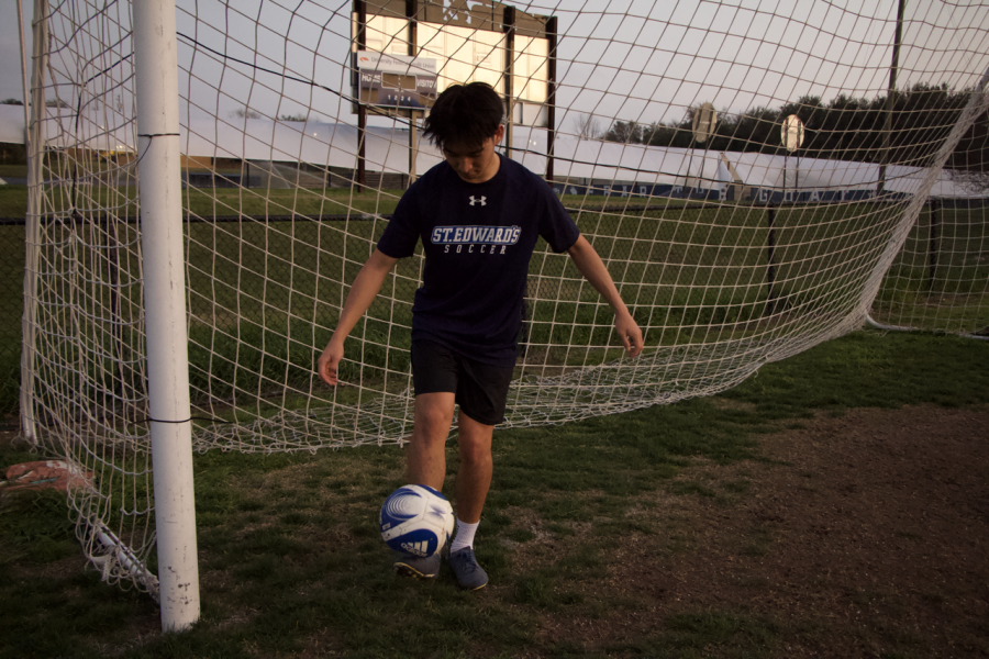 Freshman center midfielder Shunji Watanabe balances a soccer ball on his foot during the club teams evening practice.