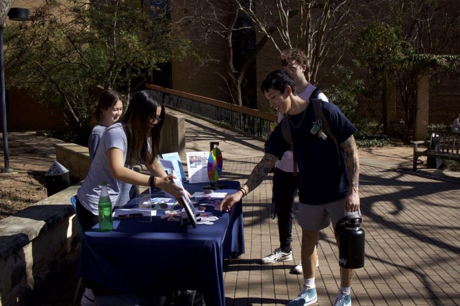 Students passing by the outreach table stop to take a look at activities and resources. 