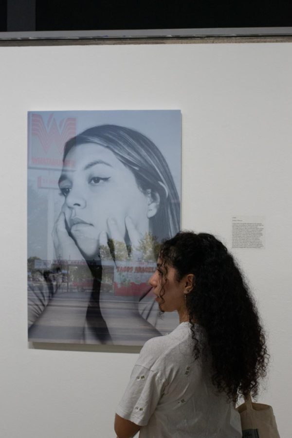 An attendee examining Sydnee Villarreals artwork.