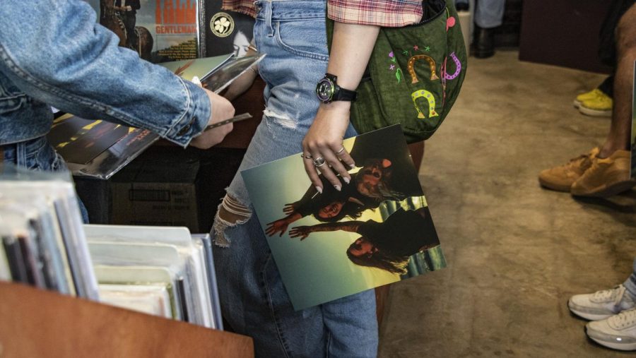Fans linger in the lobby of End of an Ear's vinyl haven, creating a hub for music lovers as they discuss favorite tracks and aesthetics of Boygenius.