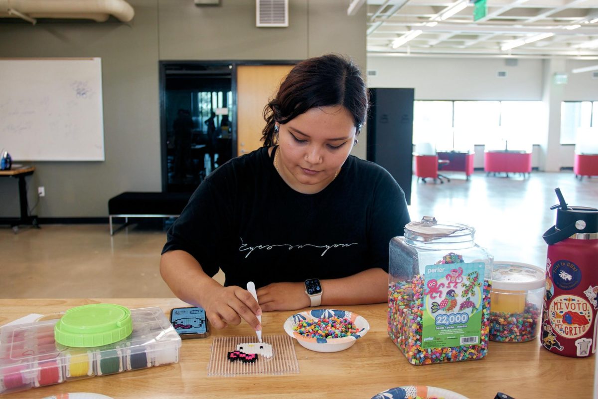 Library+aid+Patricia+Martinez+demonstrates+pixel+art+by+creating+a+Hello+Kitty+made+of+perler+beads.