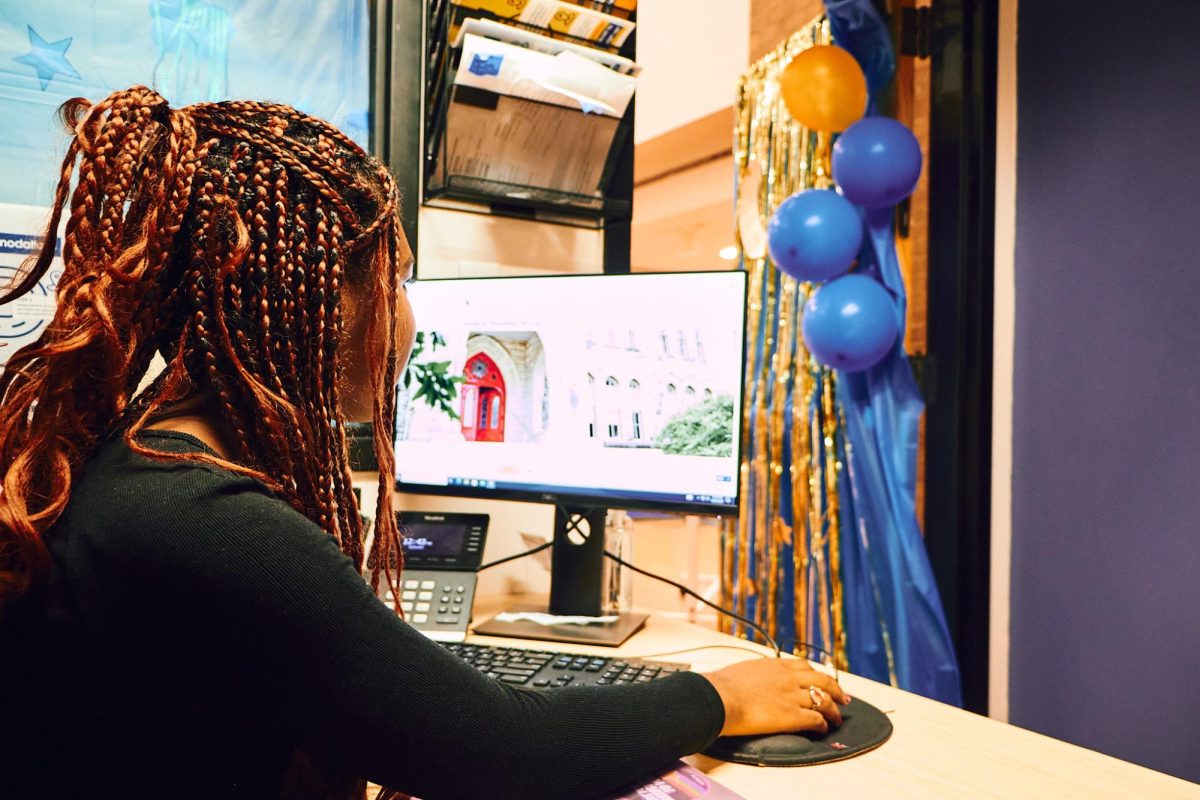 Abenet Hinton, an SDS student worker sits at her desk within the International Student Services office. The ISS office is where many International students can find various resources and is presumably representing over 50 countries on the hilltop. 