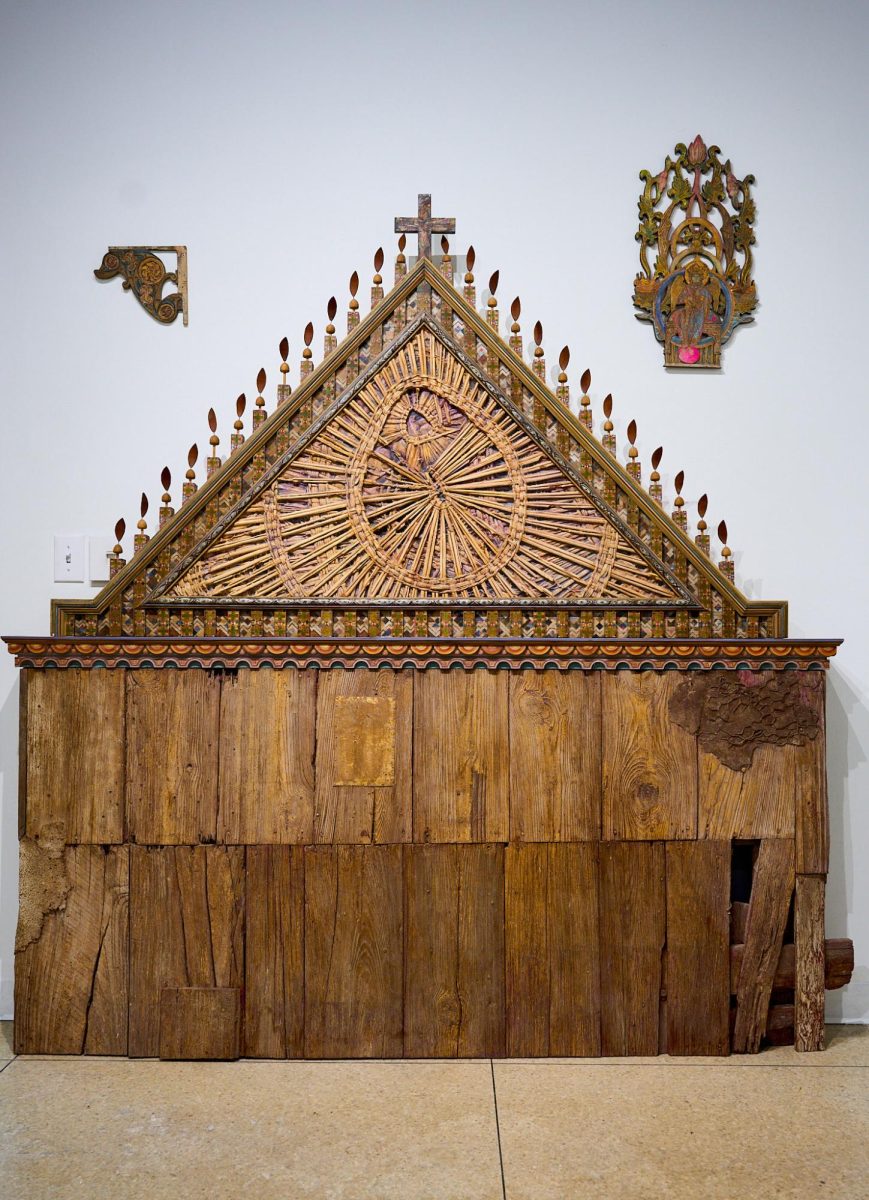 A wooden alter-like structure, handcrafted by Cobb, stands at the front of the gallery. Its many details capture the eye.